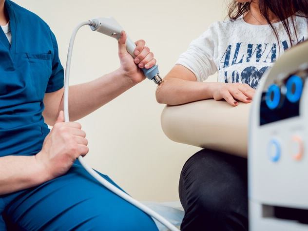 Profissional usando um aparelho de exame no braço de uma paciente